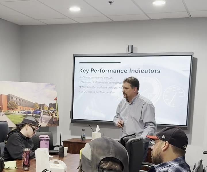 Jason Dixon presenting a Key Performance Indicators slide to a production crew in a conference room